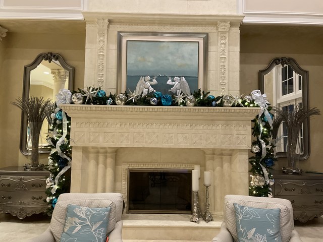 A carved limestone mantel dressed in blue, silver and white