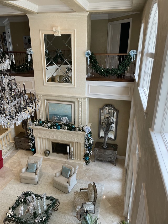 The two story room from above, garland on the rail and the mantel below
