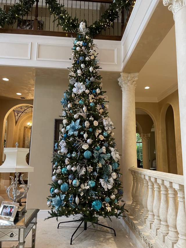 A tall tree in blue and silver beside the staircase