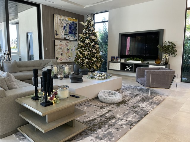 A modern living room with a decorated tree by the windows