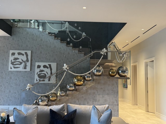 A floating staircase hung with mercury glass spheres and a beaded garland
