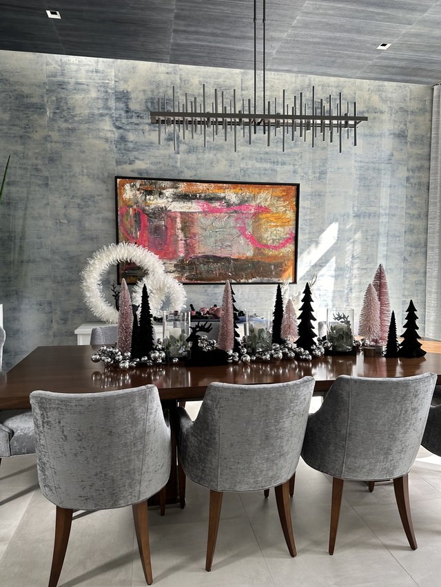 The dining table from the end, with velvet chairs and tapered trees
