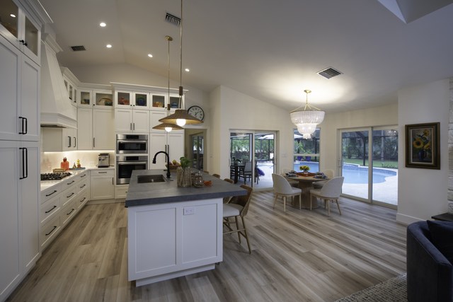 A white kitchen with a range wall and sliding doors out to the pool