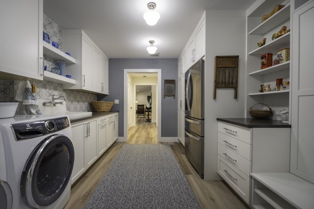A laundry room with open shelving and a runner down the center
