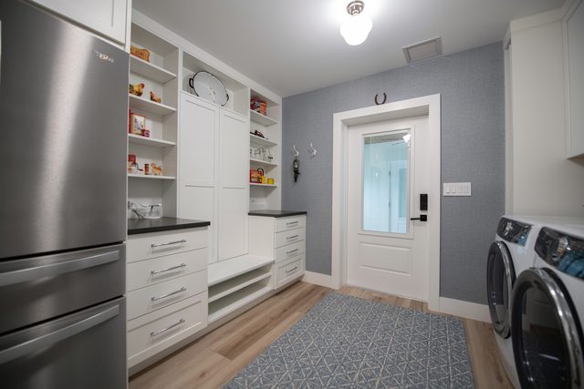The same laundry room from the other end, with a built-in bench and the back door beyond